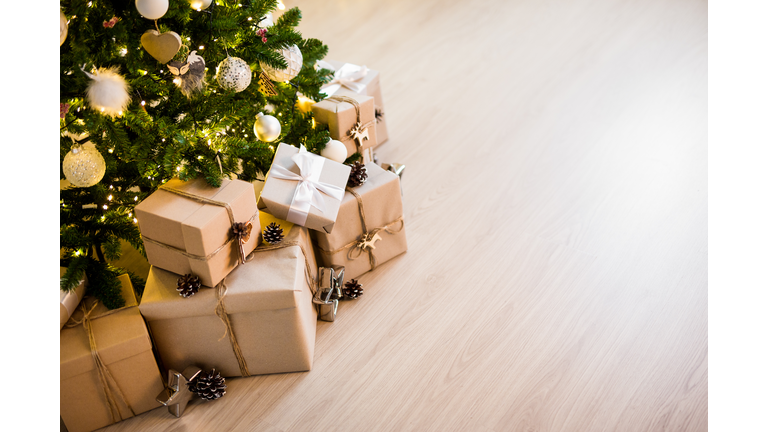 christmas tree and heap of gift boxes - copy space over wooden floor background