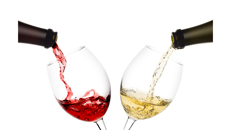 red and white wine poured from a bottle into wine glass on white background, isolated