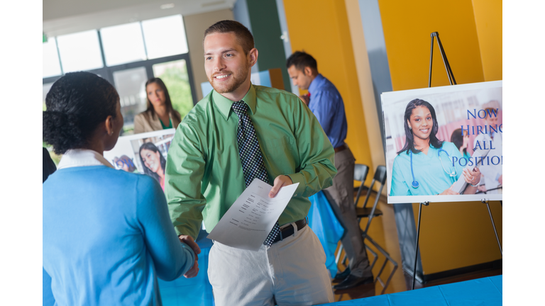 Professional man shaking hands with executive at job fair event