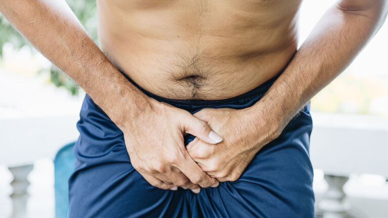 Close up of a man with hands holding his crotch, Urinary Tract Infection concept Painful Bladder Syndrome and interstitial cystitis