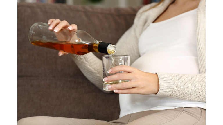 Irresponsible pregnant woman drinking alcohol