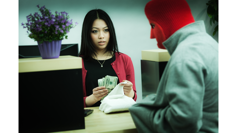 Criminal Robber Robbing an Asian Retail Bank Teller at Counter