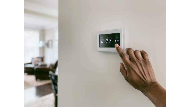 Woman Adjusts Thermostat