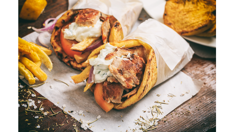 Greek gyros wraped in a pita bread on a wooden background