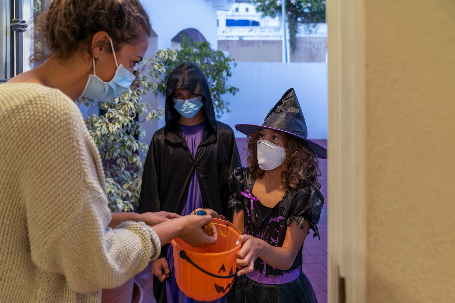 Children Dressed In Halloween Costumes Trick-Or-Treating In COVID-19 Times
