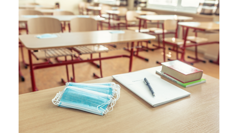 Face mask on a teachers and school desk in a school classroom.