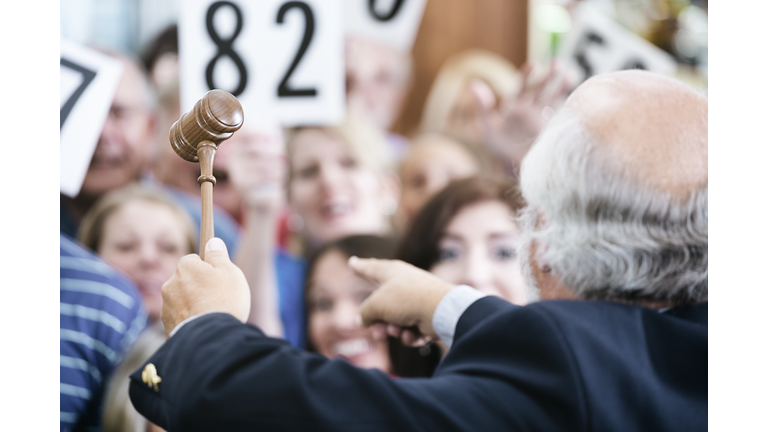 Auctioneer with Large Crowd of Buyers