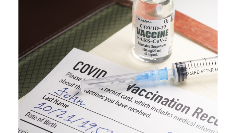 Covid-19 vaccination record card with syringe and vial