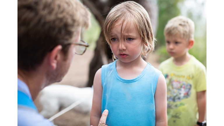 Parent disciplining and talking to his kid.