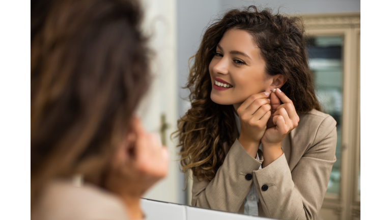 Woman putting earrings