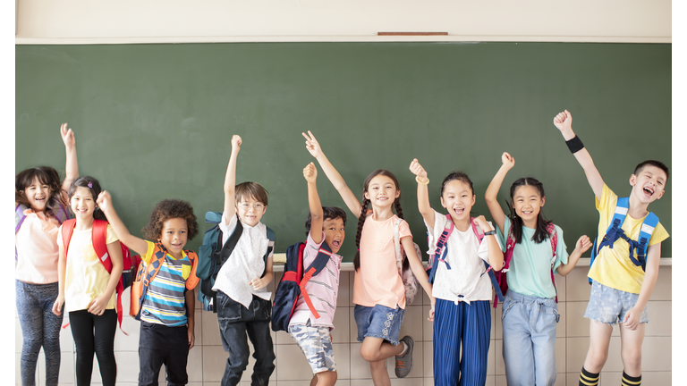 Group of diverse young students standing together in classroom