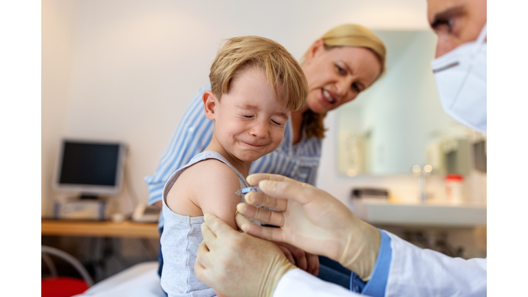 Little boy feeling pain while getting a vaccine