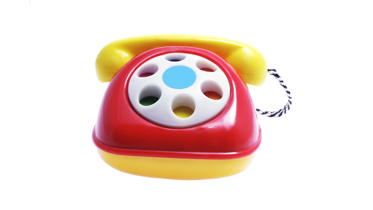 Red and yellow toy phone on white background 