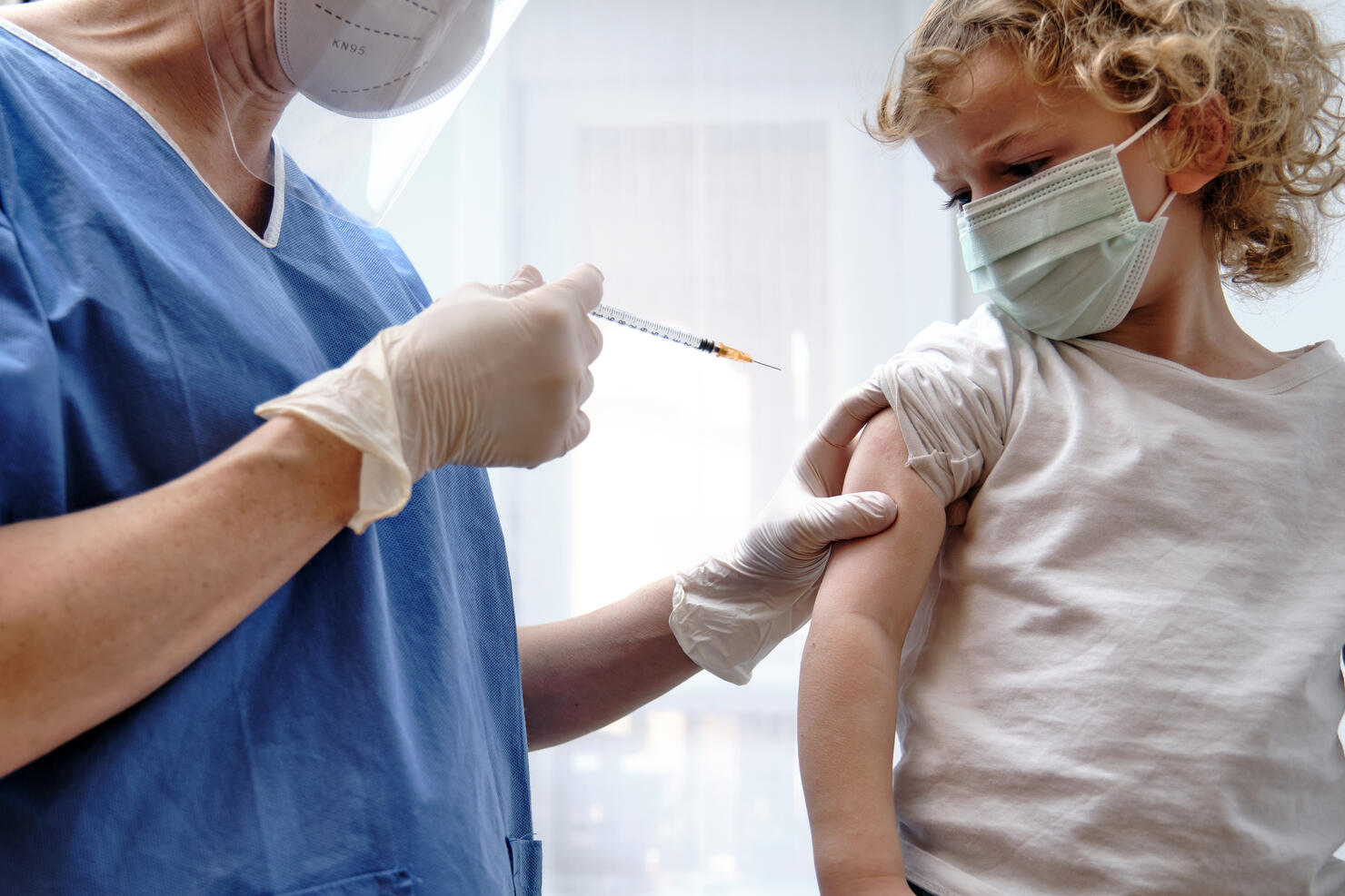 Female doctor giving covid-19 vaccine to a toddler