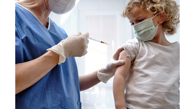 Female doctor giving covid-19 vaccine to a toddler