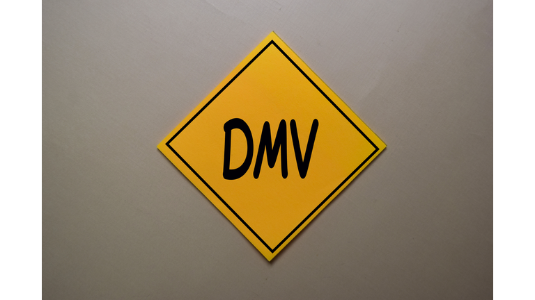 DMV write on a sticky note isolated on office desk.