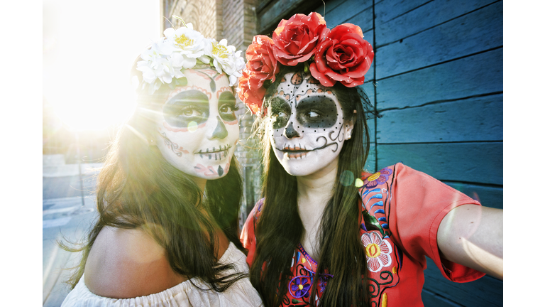 Women on sidewalk wearing skull face paint