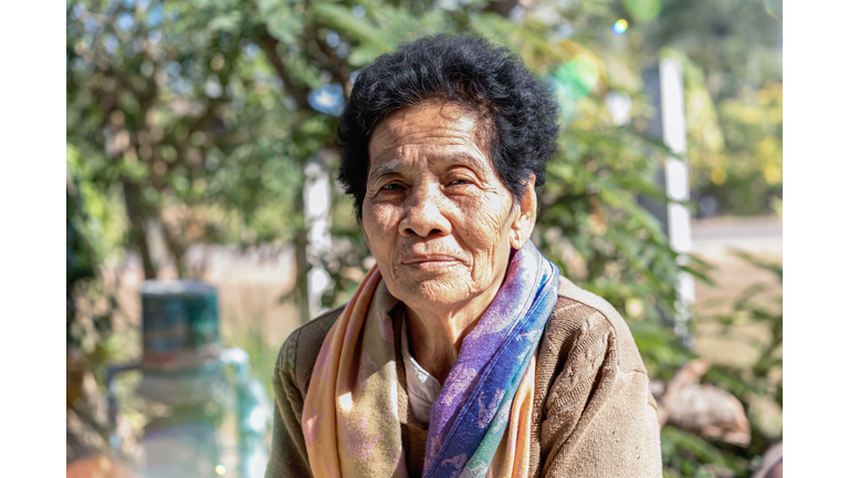 Close-up of old Asian woman face with wrinkles elderly senior"nsmiling happiness, and looking at the camera. Asian senior woman healthy and have positive thoughts on life. Healthcare concept