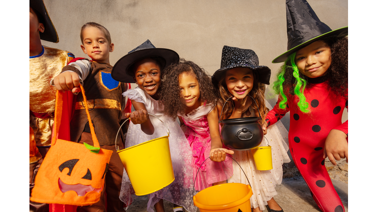 Halloween kids group together with candy buckets