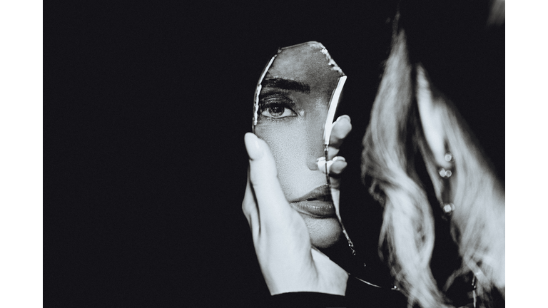 Black and white portrait of woman and broken self-image mirror