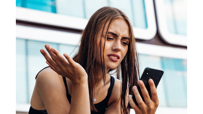 Bad News Young Woman Reading Messages on Mobile Phone