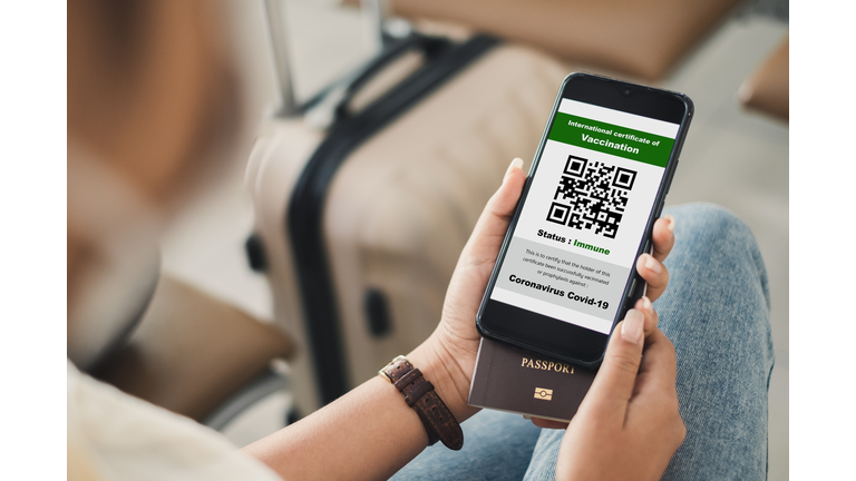 Traveler shows health passport of vaccination certification on phone at airport, to certicy that have been vaccinated of coronavirus covid-19