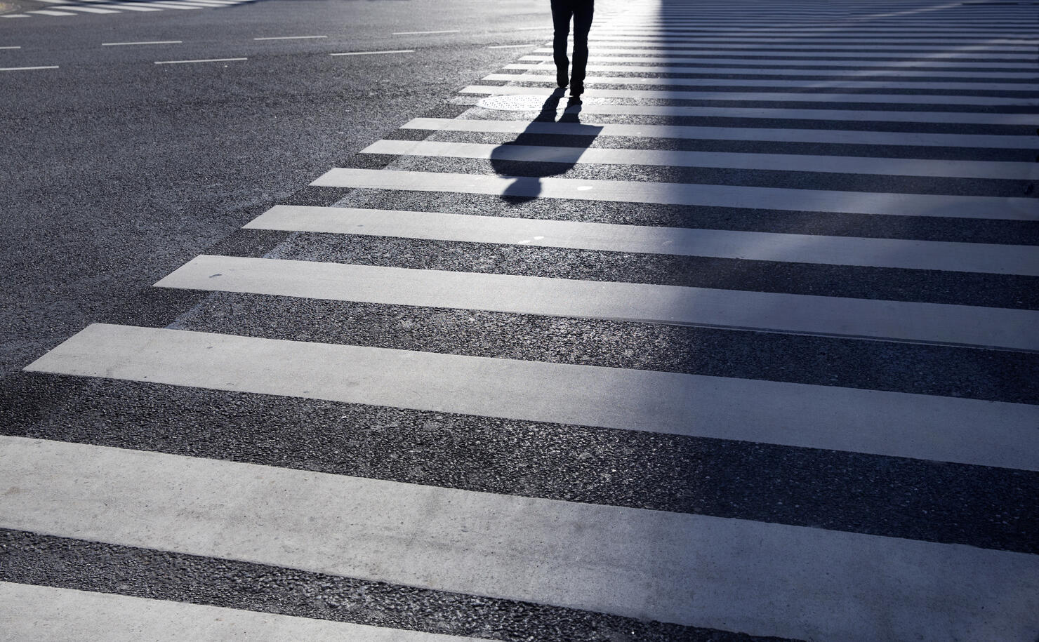 Man walking across large intersection.