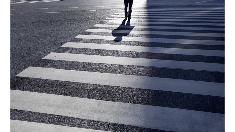 Man walking across large intersection.