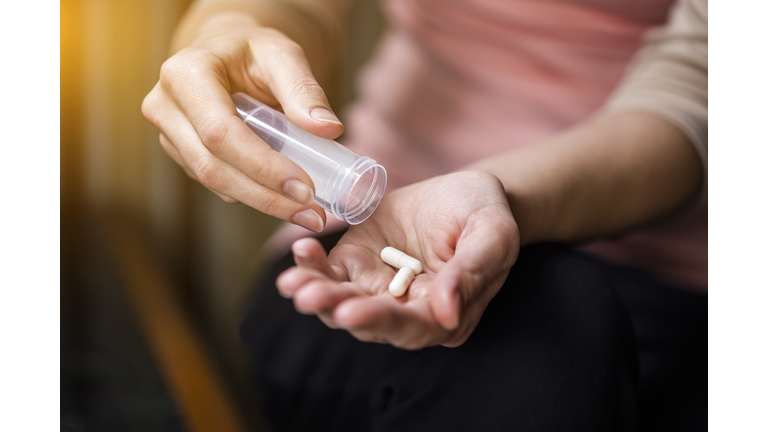 Woman taking pills close-up