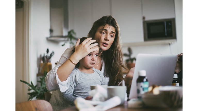 Mother with sick son taking advice on video call at home