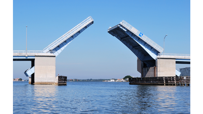 Blue and Steel Drawbridge Opening From On Water Perspective
