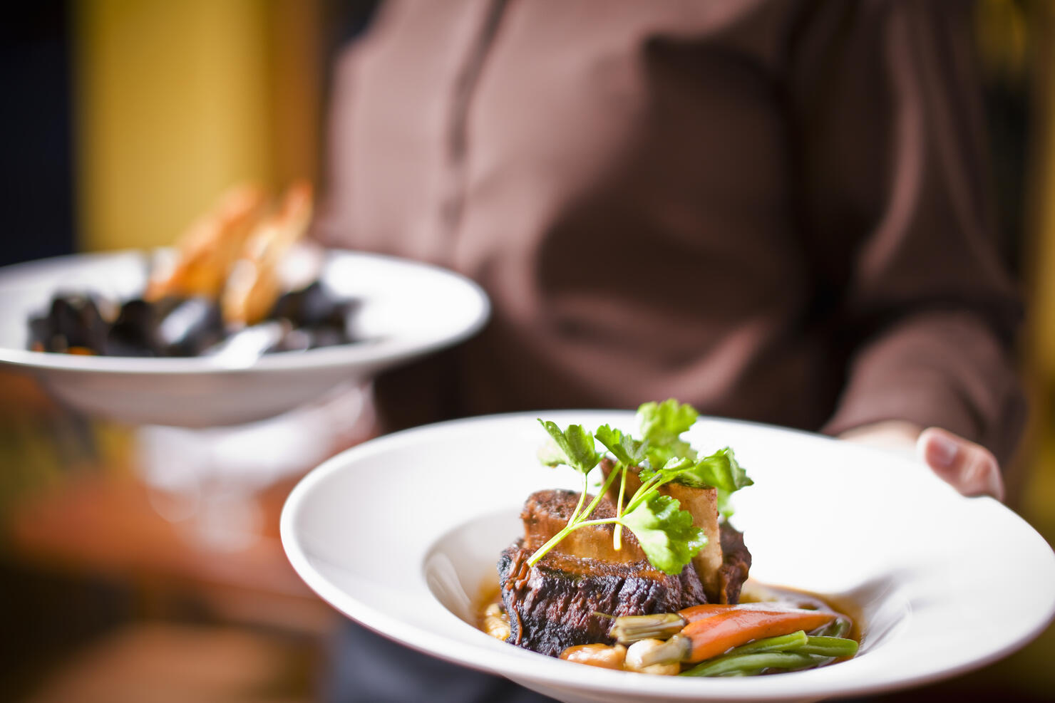 Waitress holding plate of beef tenderloin