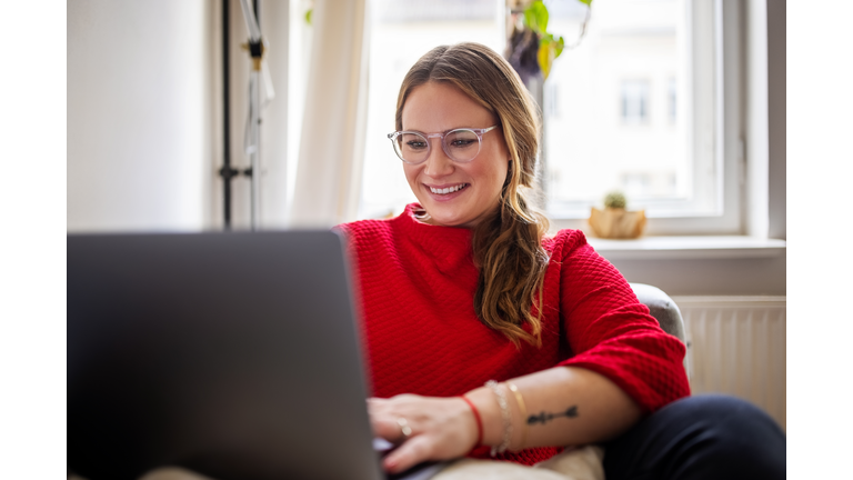 Happy woman working on laptop at home