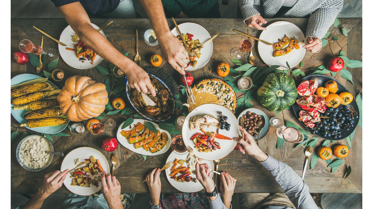 Flat-lay of friends feasting at Thanksgiving Day table with turkey