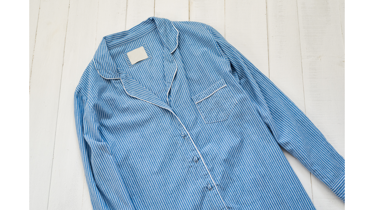 Blue striped pajama shirt on a white background. Clothing concept