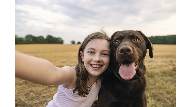 Girl taking a selfie with her pet dog