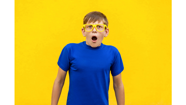 Wow! Portrait of  freckled boy with shocked facial expression.