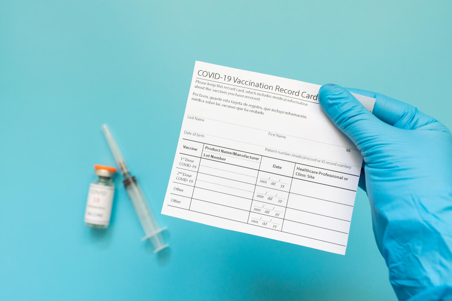Doctor is holding a vaccination record card and corona virus vaccine vials. Passport of immunity to the coronavirus in the hands of a male doctor. Health passport.