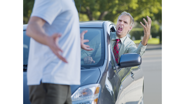 Angry driver shouting at pedestrian blocking road