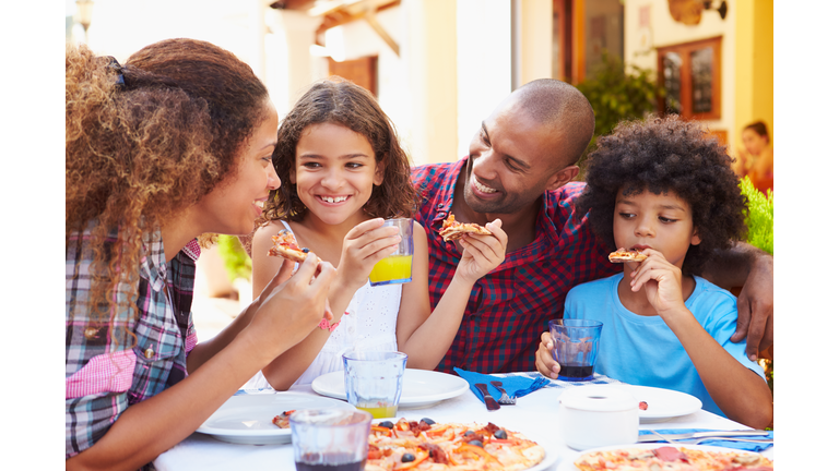 Family Eating Meal At Outdoor Restaurant Together