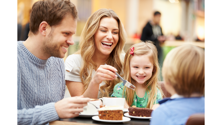 Family Enjoying Snack In Café Together