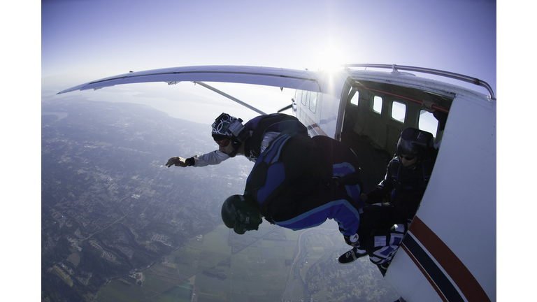 Two skydivers jumping out of airplane, aerial view