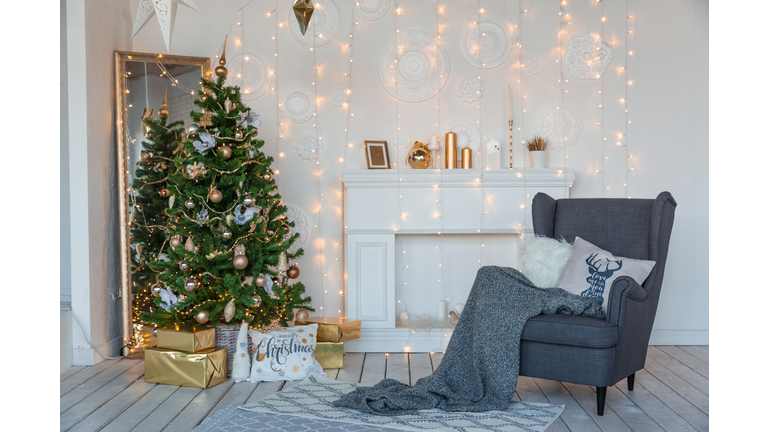 Modern design room in light colors decorated with Christmas tree and decorative elements