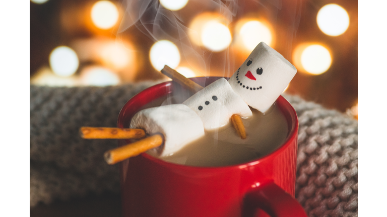 Red mug with hot chocolate with melted marshmallow snowman