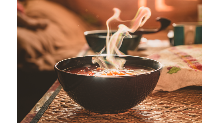 Hot vegetable soup in a dish made of natural materials. Traditional family lunch in a Russian village