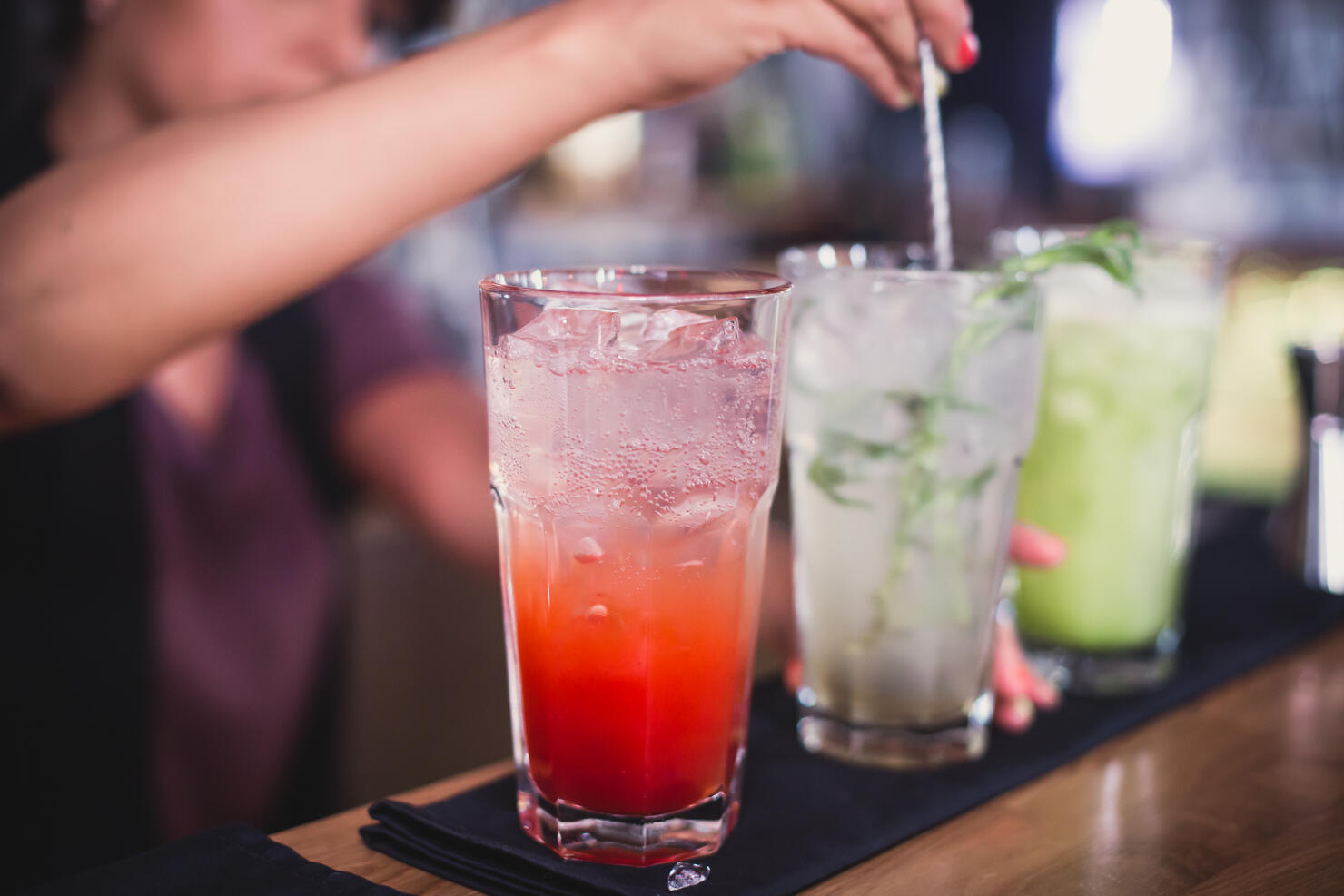 line of different coloured alcohol cocktails on a open-air party