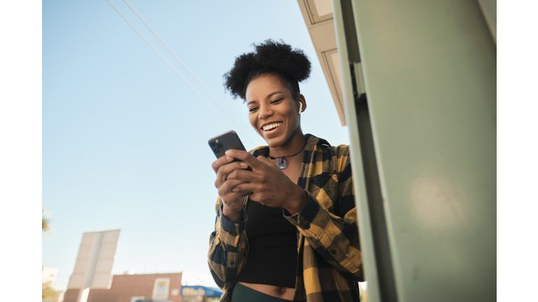 Mid adult woman laughing during video chat in smart phone