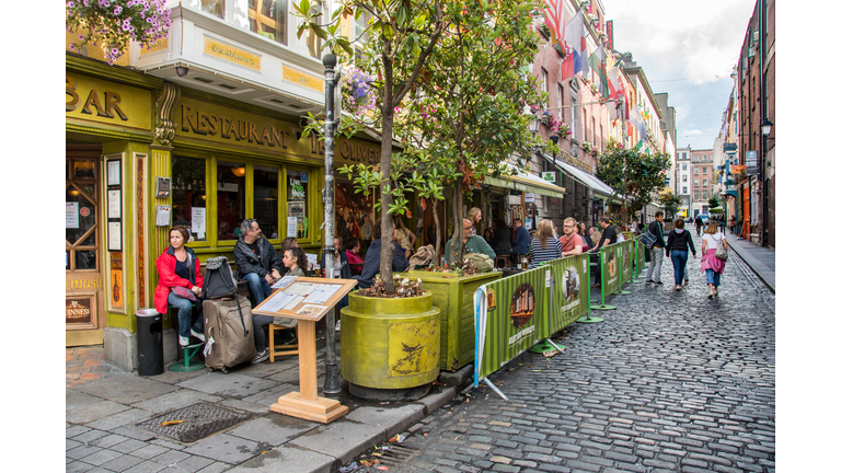 People dining outside of a traditional Irish bar