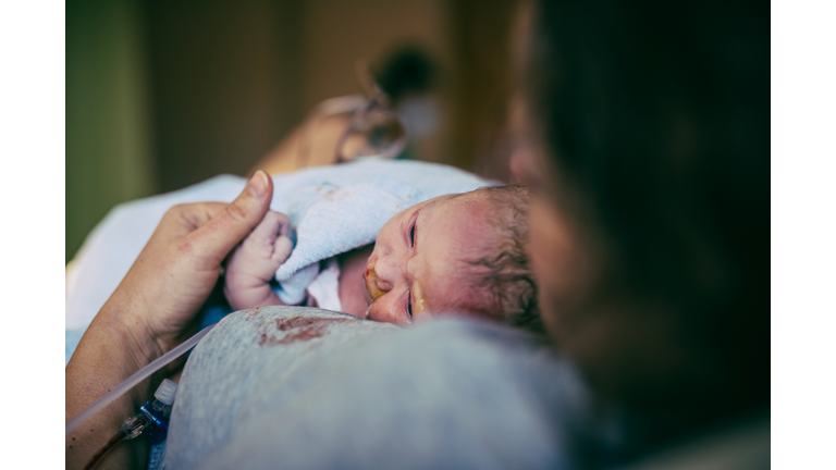 Woman holding her newborn after birth in hospital.