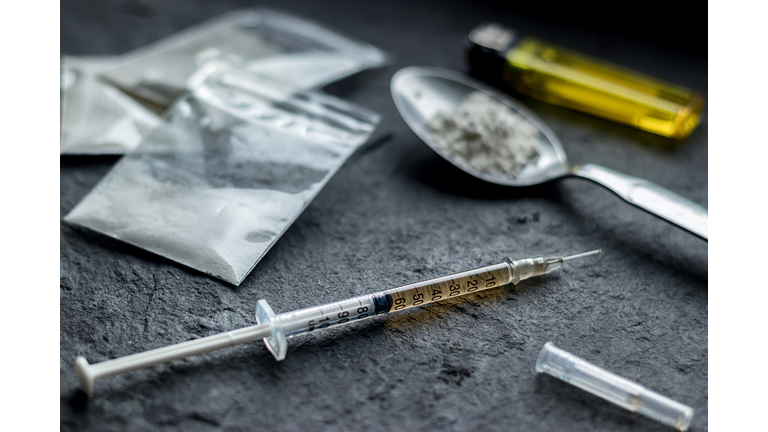 drug syringe and cooked heroin on spoon. drug addict problem and therapy concept